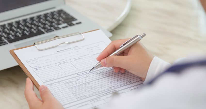 Hand of doctor writing on prescription